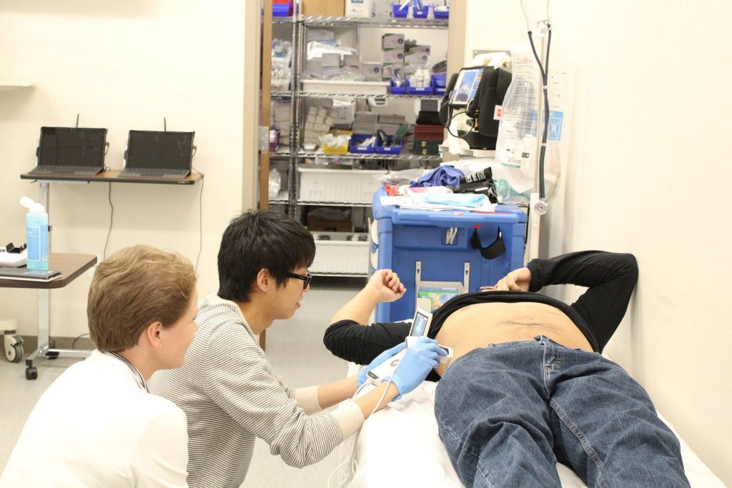 Abigail Etters, Chris Kim, and Robert Lyday practice ultrasound skills.
